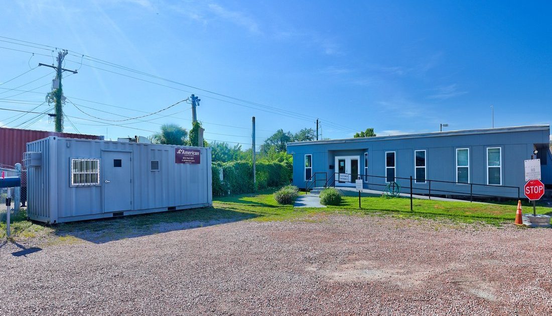 gray 20-foot container office sitting next to A American main office at Tampa lot