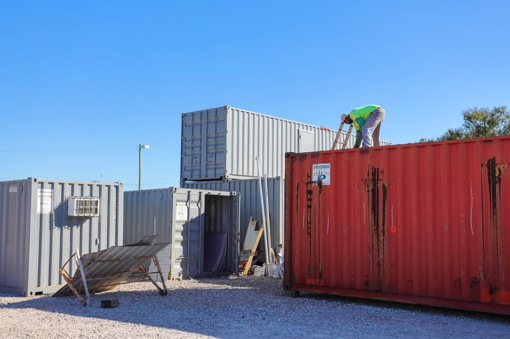 Modification team member on top of red shipping container 