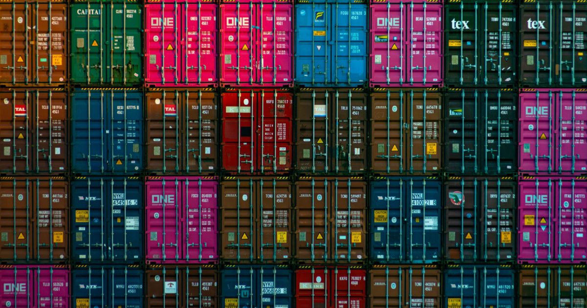 stack of containers in various colors with yellow hazard placard