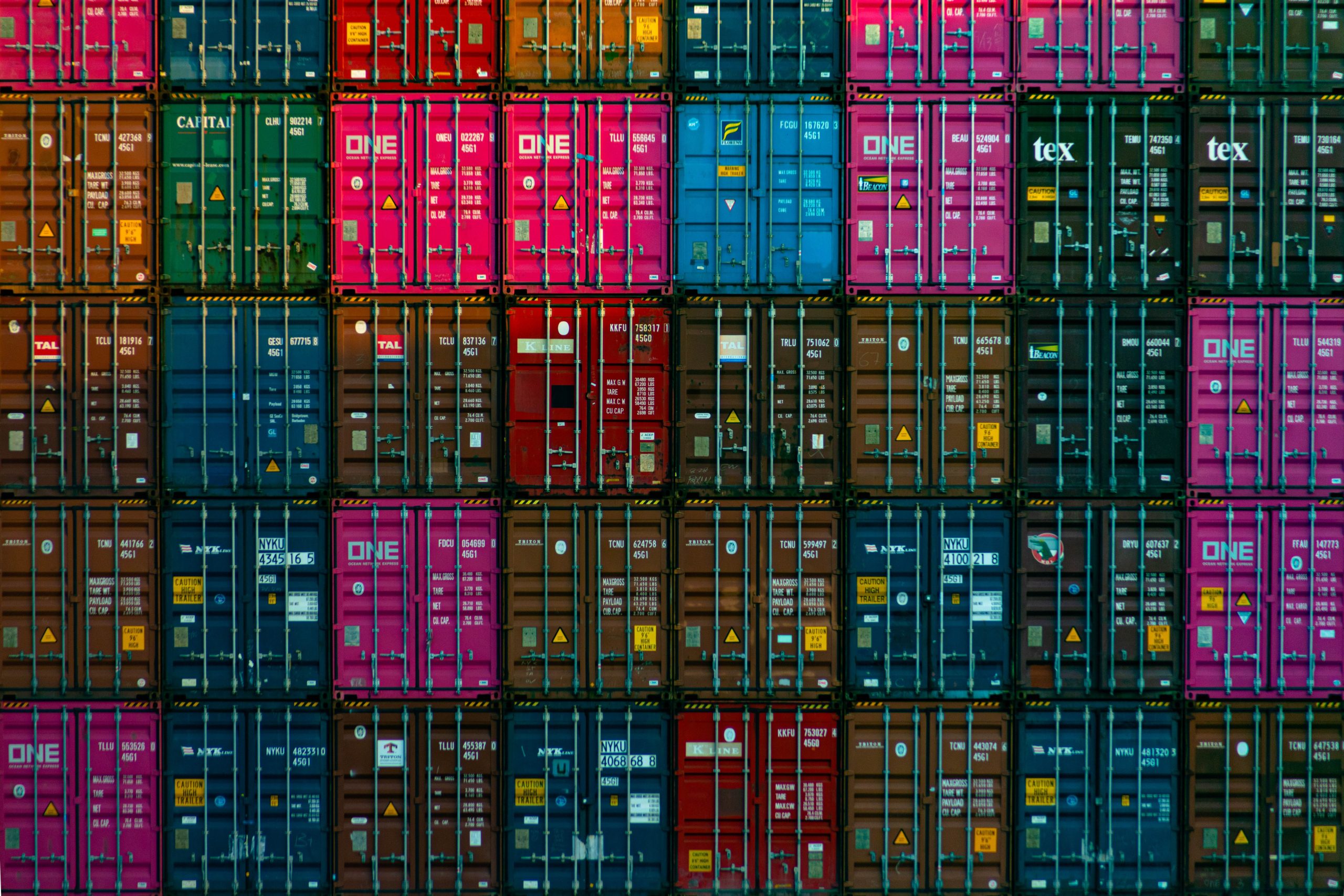 stack of containers in various colors with yellow hazard placard